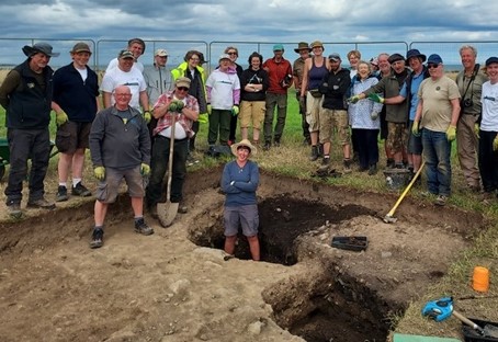 Group of people next to excavated hole